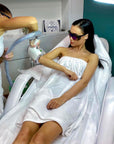  esthetician performs laser hair removal treatment on a woman’s arm